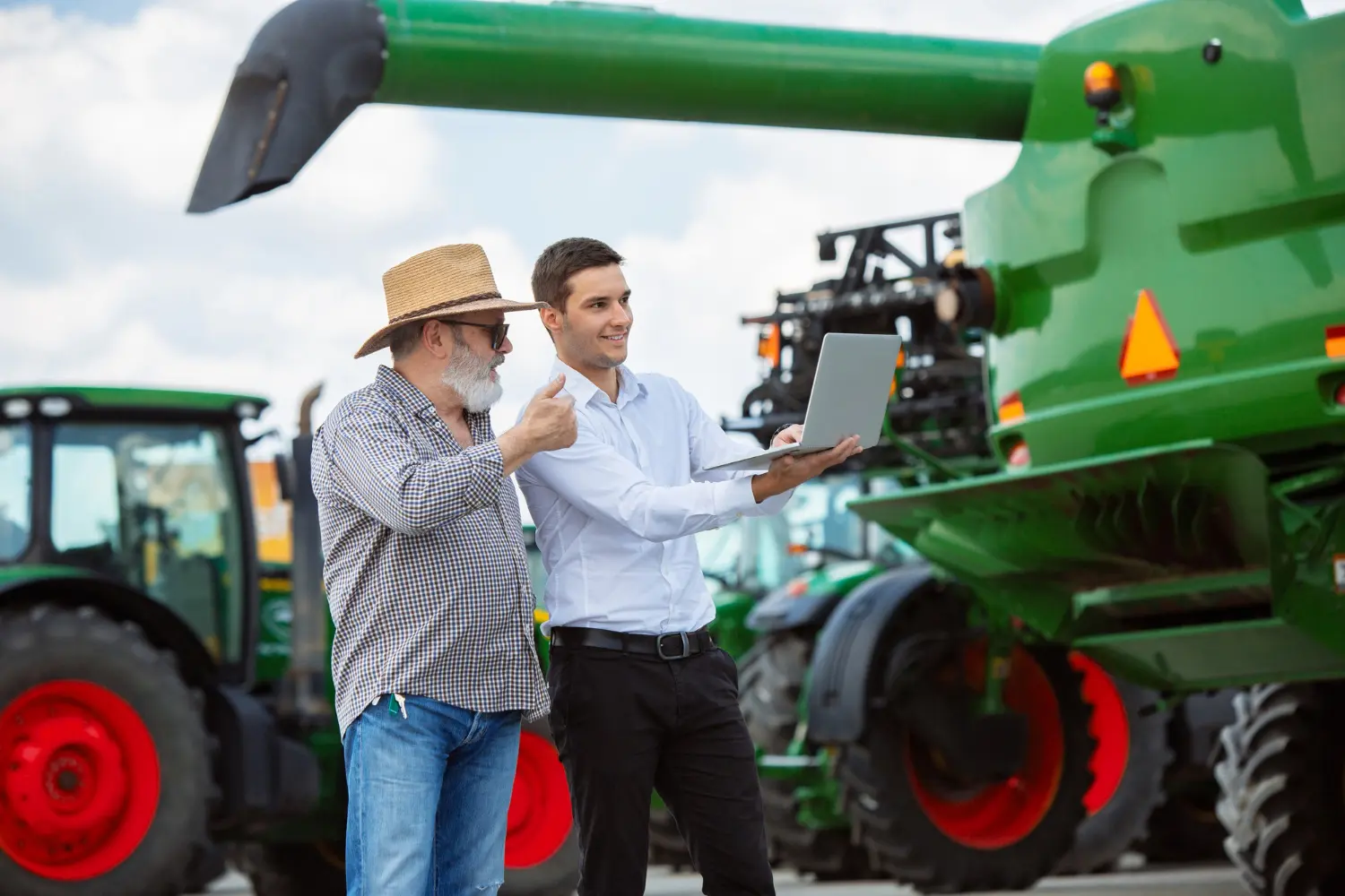 Farm mechanic inspecting agricultural machinery with farmer for Australian tax deductions and compliance